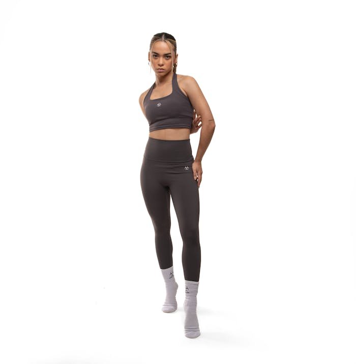 Home Confident woman in stylish sportswear posing in a bright studio setting. Perfect for fitness and fashion themes.